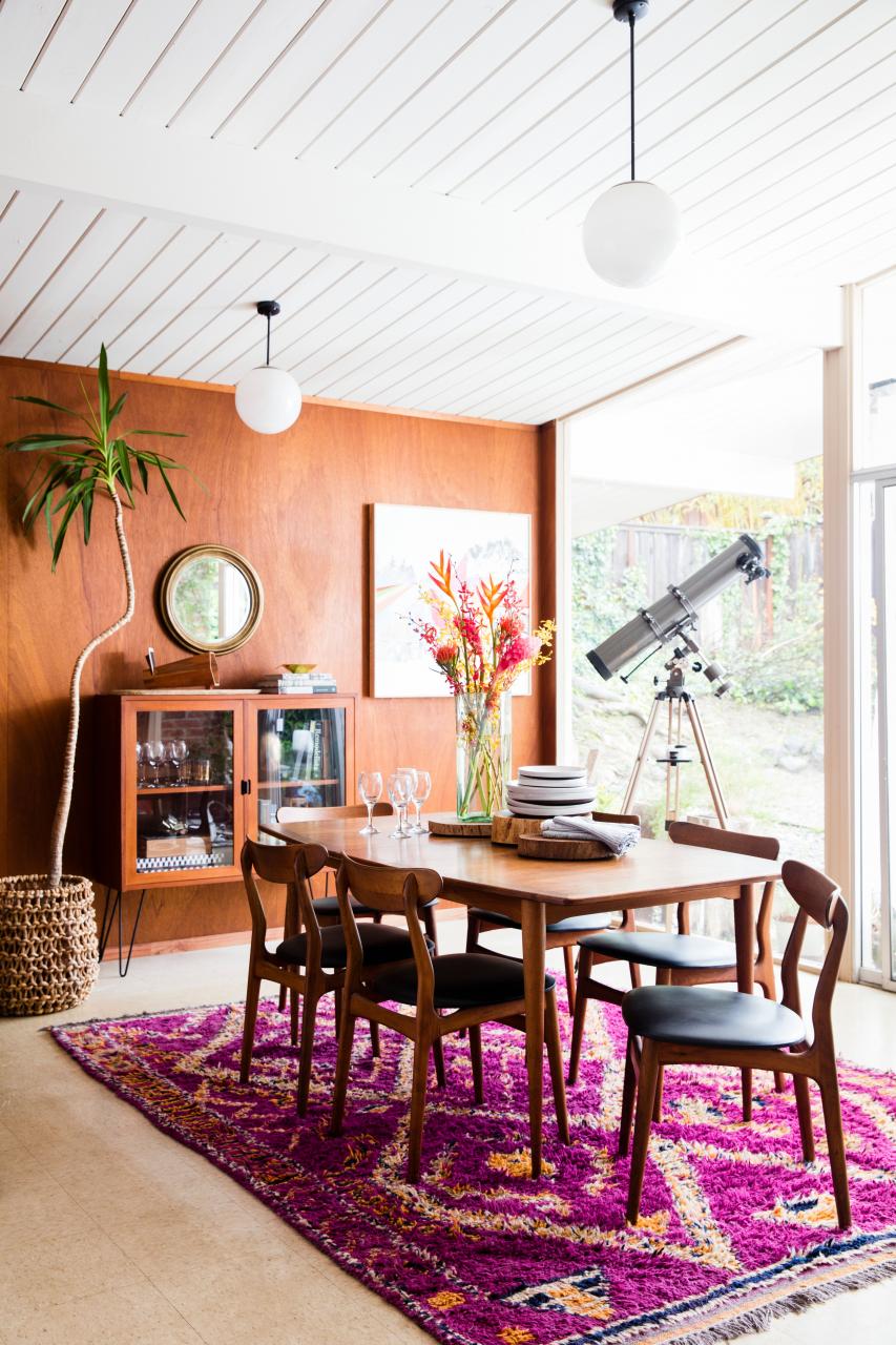 a cozy light filled dining room with a telescope and a pink rug