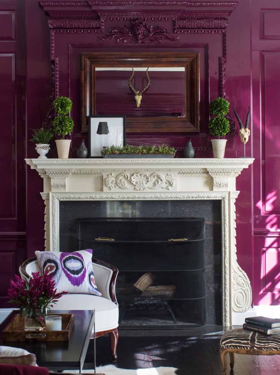 Bold purple living room with painted molding and a white mantel