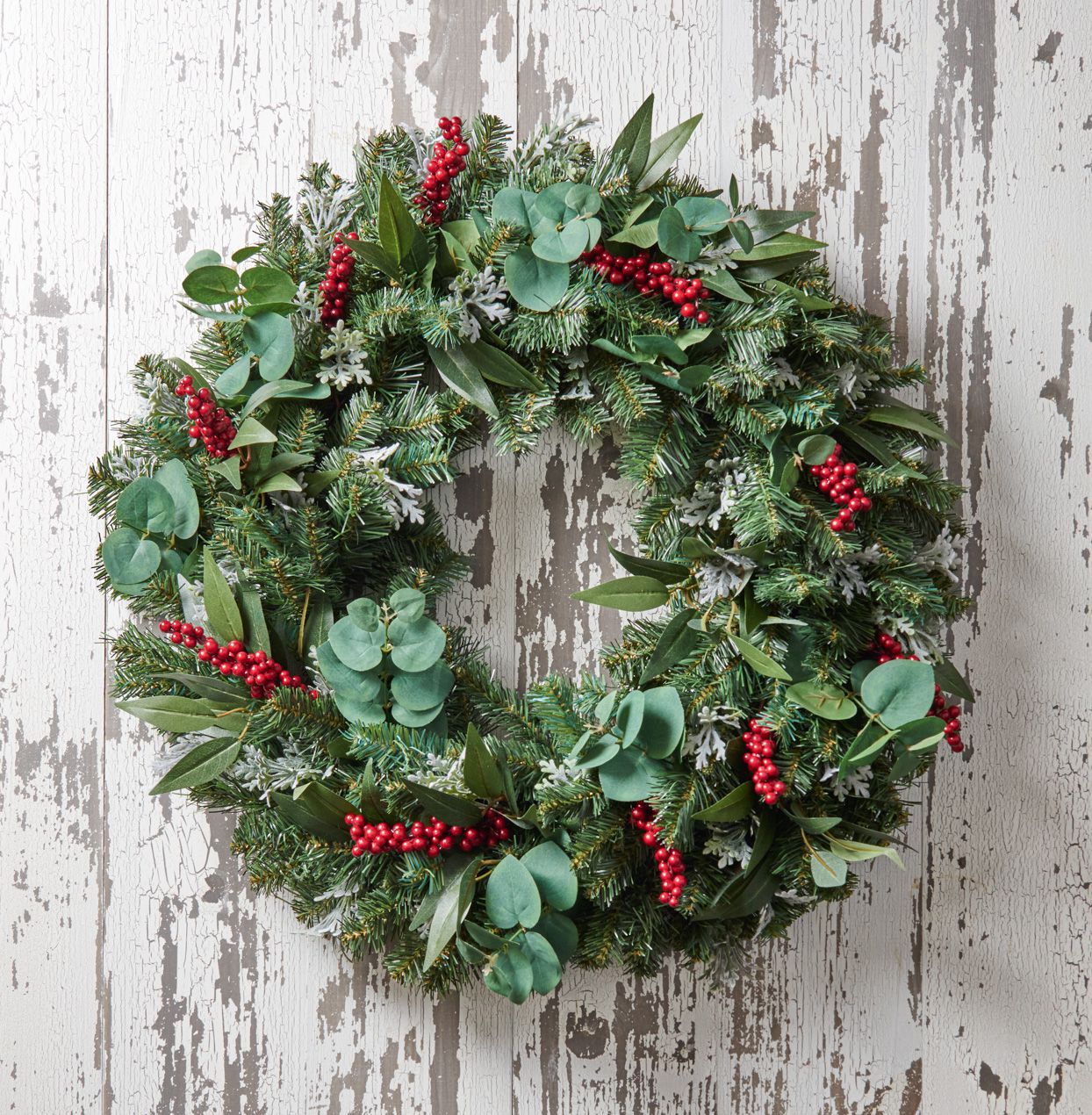 Red berry accented wreath rustic wood