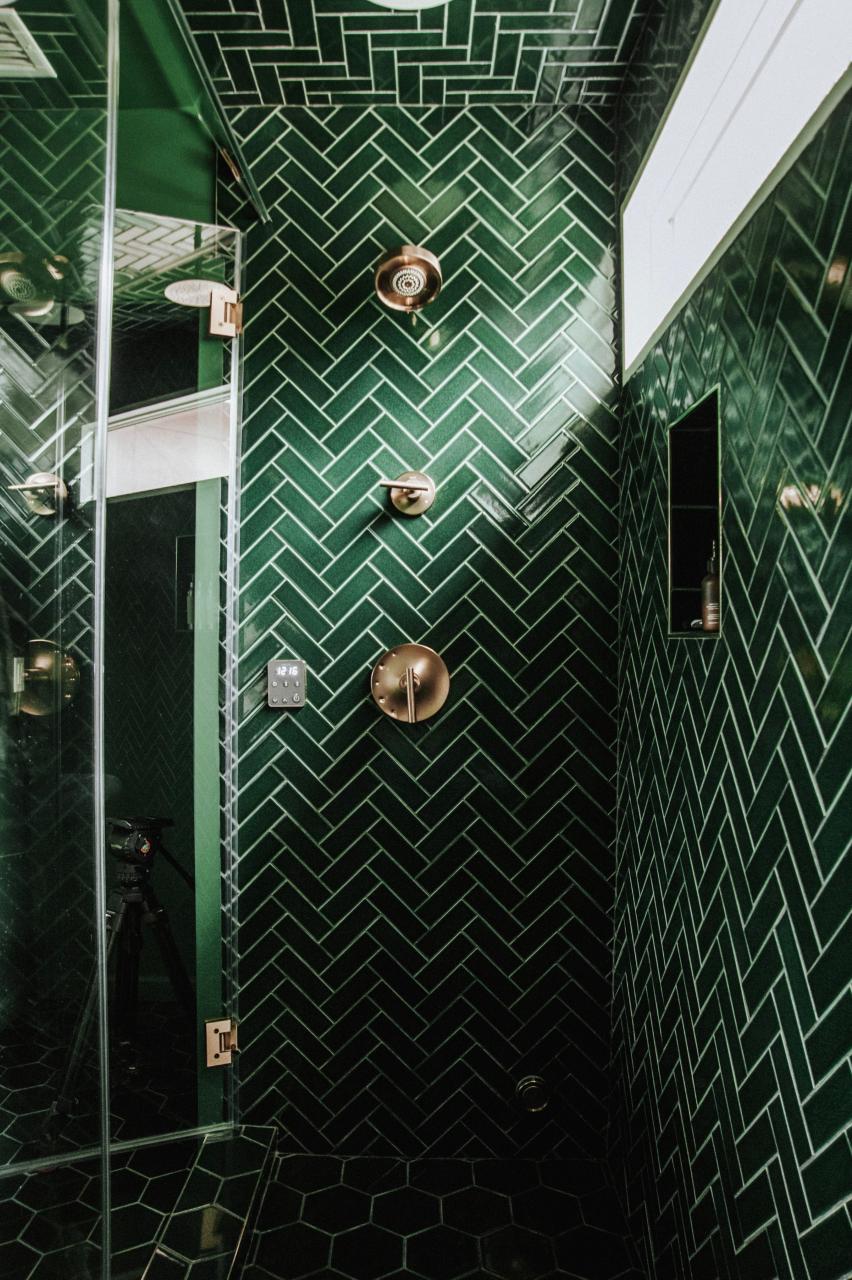 walk-in shower in bathroom with green tile chevron design