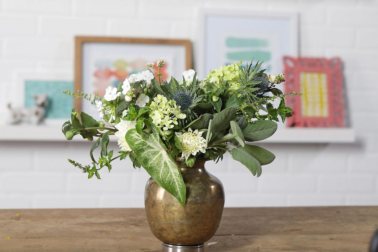 Green and white fall flower arrangement in pot on table