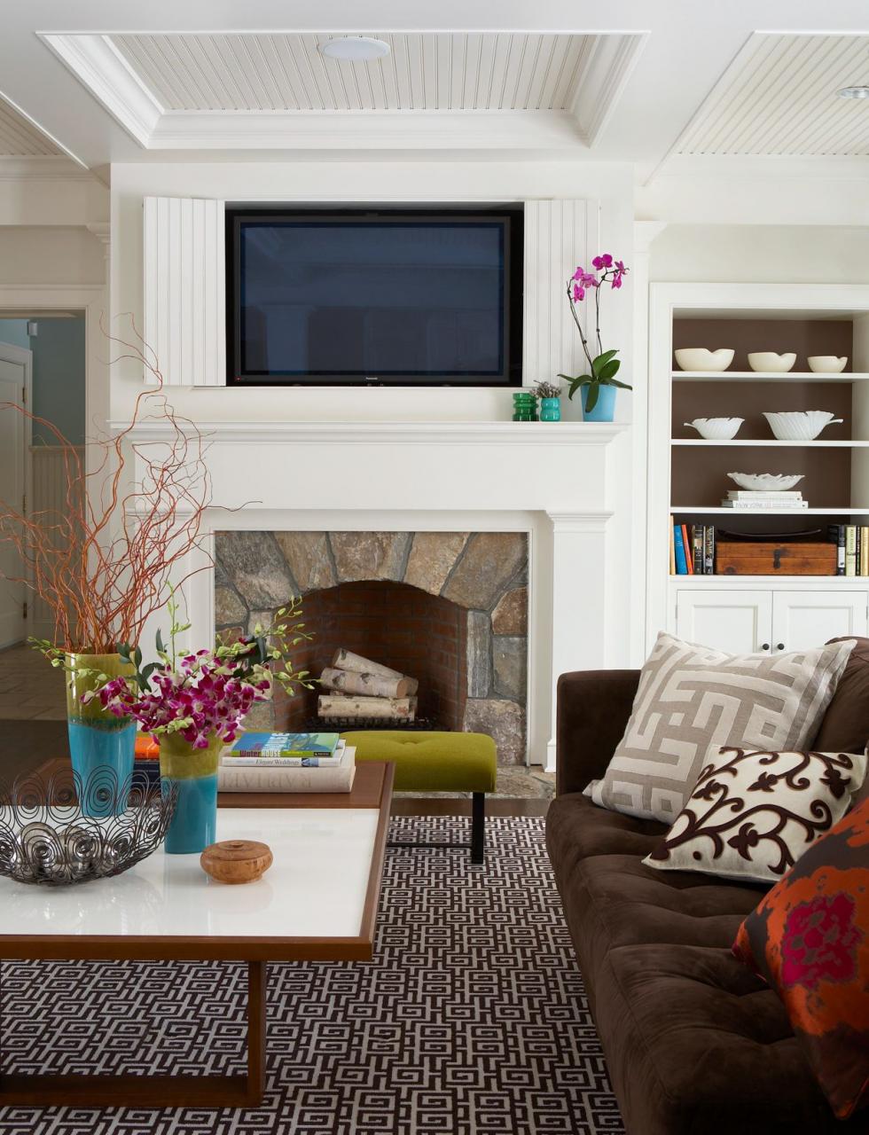 living room with fireplace, tv, and patterned rug