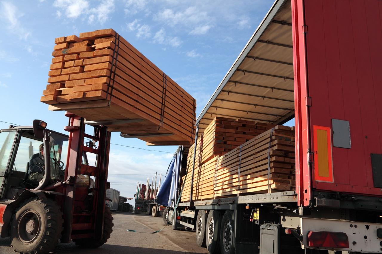 forklift lifting lumber onto lumber truck